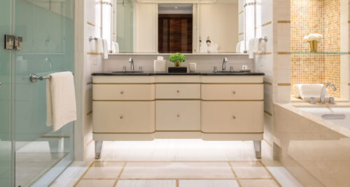 A granite vanity separates a soaking tub and shower in the bathroom of this suite